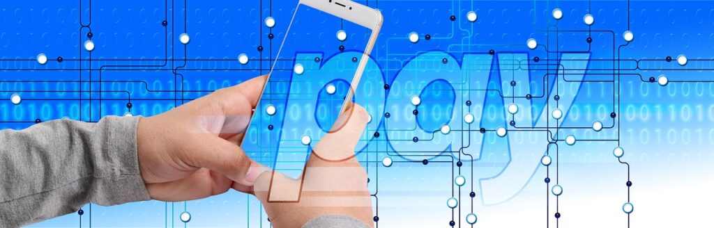 Manos sosteniendo un teléfono móvil con la palabra Pay y fondo tecnológico, ilustrando los pagos digitales y transacciones cripto